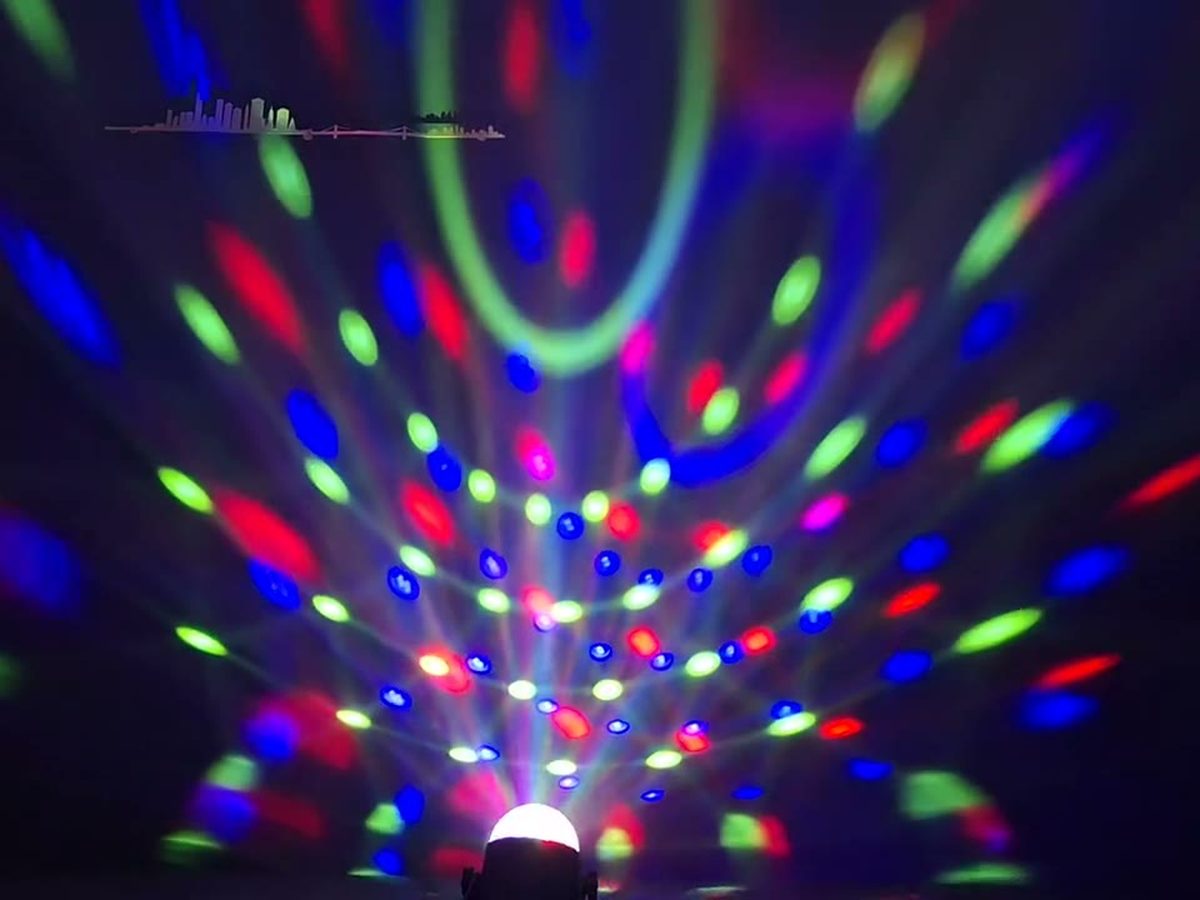 Boule disco LED posée au sol, projetant des pastilles bleues sur le mur