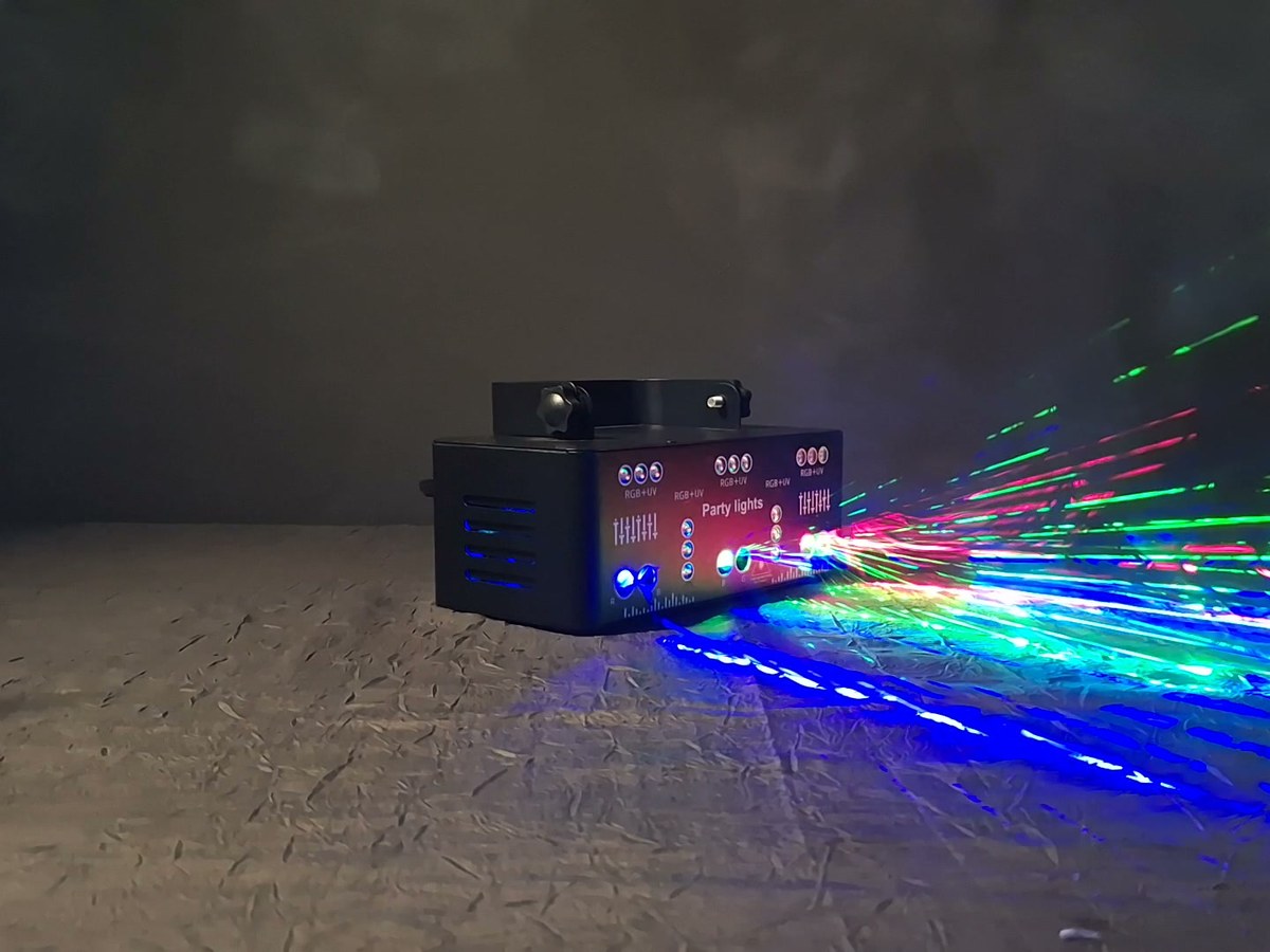 Projecteur laser noir envoyant une nappe de faisceaux verts, rouges et bleus dans la pièce