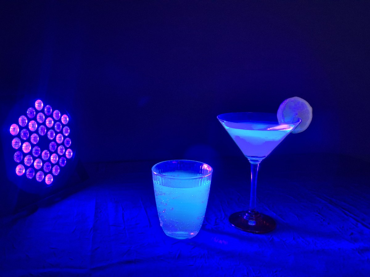 Projecteur UV à 36 LED et deux verres de cocktail devenus fluorescents sous la lumière noire