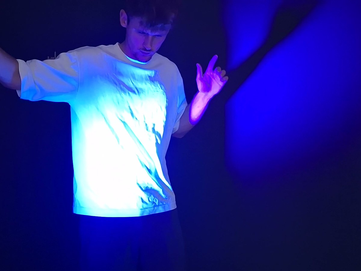 T-shirt blanc devenu fluorescent sous le projecteur à lumière noire