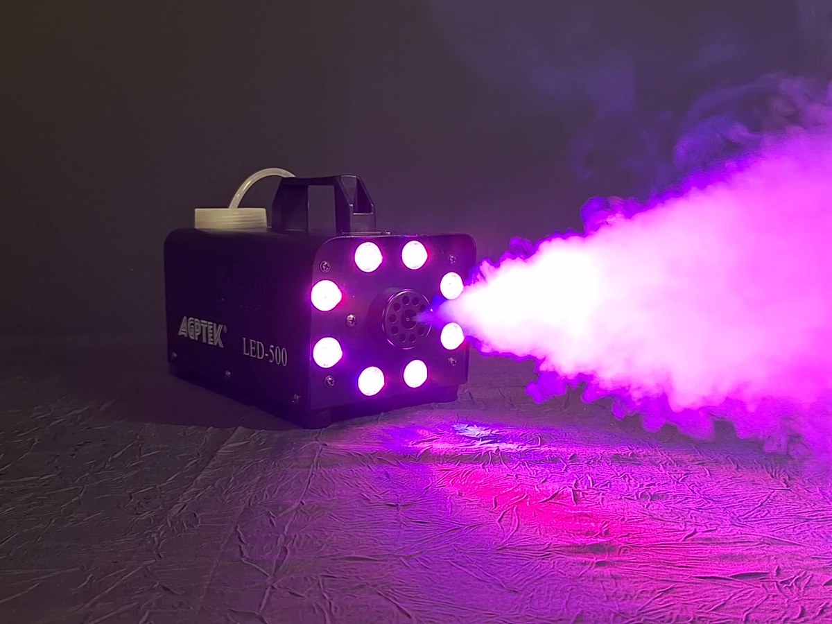 Machine à fumée noire projetant un jet de fumée éclairé en rose