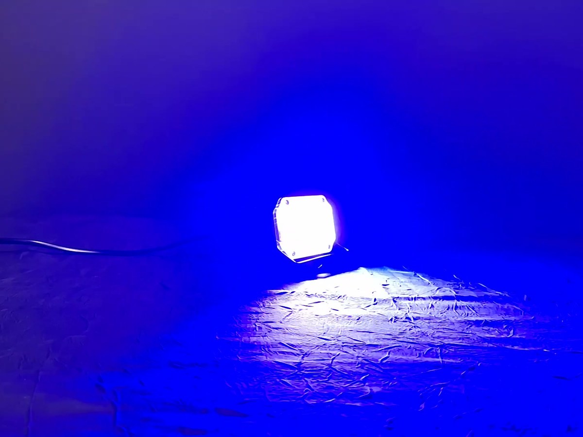 Stroboscope LED posé au sol, son flash bleu éclairant toute la pièce